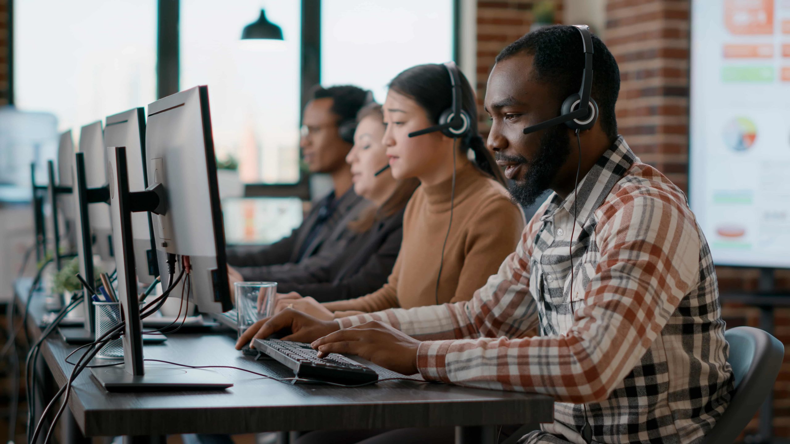 A few customer service employees assist customers with the help of contact center automation.